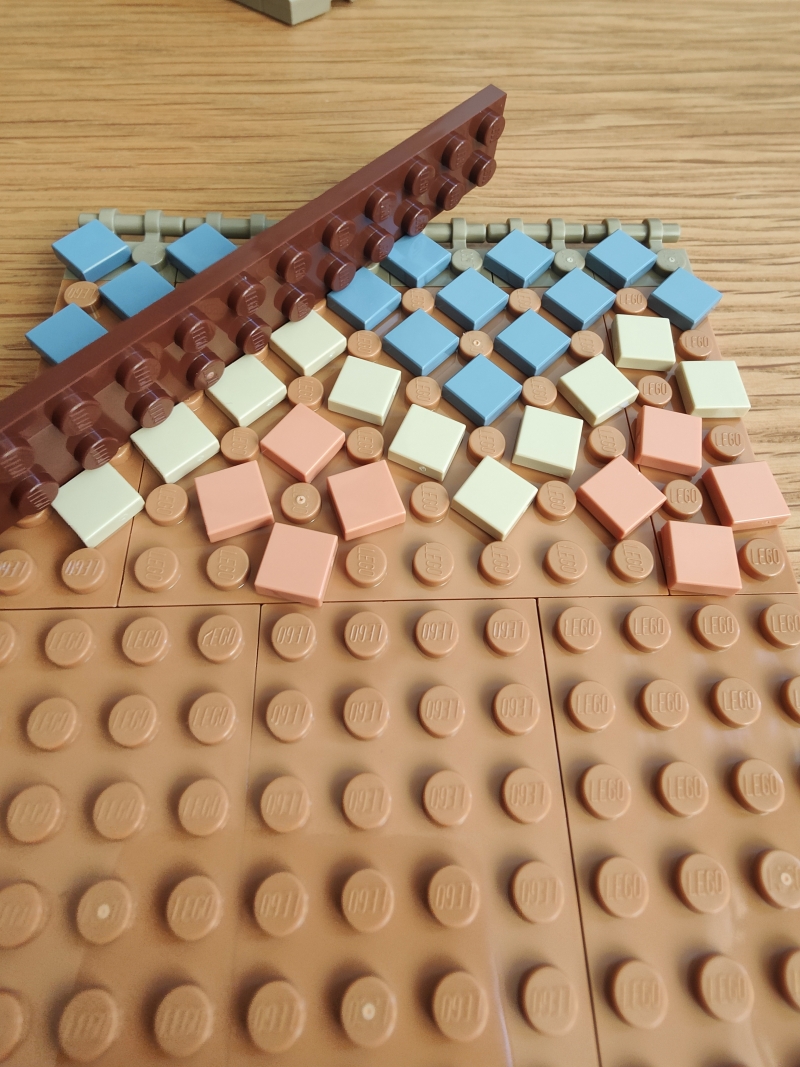 Utilsier une règle pour aligner les tuiles, l'idée de génie pour magnifier le set Lego Le Seigneur des Anneaux : Fondcombe.